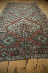 Angled view down the length of a distressed Soumac carpet, highlighting its triple medallion design.