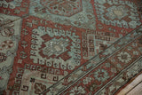 Geometric hook-and-latch motifs in chestnut and powder blue on a vintage distressed Soumac carpet.