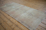 Faded ivory and blush tones with visible foundation wear on a distressed Oushak runner.