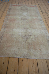 Distressed pile detail of a vintage Oushak runner, showing wear and muted ivory hues.