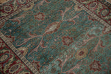 Kayseri rug with distressed ocean green field, heavy abrashes, and cherry red floral motifs.