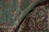 Distressed texture and abrash on folded vintage Kayseri rug in teal and cherry red.
