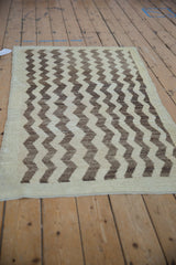 Distressed cream and coffee brown vertical chevron pattern on a vintage Tulu rug.