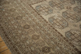 Distressed texture and camel-brown geometric border on the vintage Ersari carpet.