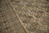 Distressed vintage Ersari rug, primitive gul medallions in time-softened camel and dusty slate.