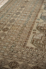 Vintage distressed Ersari carpet detail with worn gul medallions and primitive plants in camel and brown.