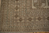 Vintage distressed Ersari carpet corner, showcasing geometric borders and muted primitive motifs.