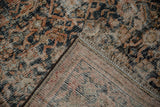 Folded corner of the vintage distressed Hamadan rug, showing worn pile and visible foundation.