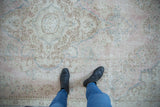 Distressed vintage Sparta carpet with faded pink, blue, and beige floral motifs.