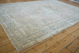 Distressed vintage Sparta carpet, faded pink, blue, ivory milfleur floral motifs, worn border.