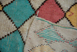 Vintage Moroccan rug showing a hand-knotted turquoise diamond and flat woven patterned back.