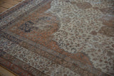 Distressed vintage Sivas carpet detail showing sprawling vinery, palmettes, and ivory and rust tones.