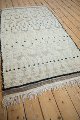 Thick ivory pile of a vintage Moroccan rug featuring black dots and natural fringe.