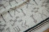 Thick ivory pile texture and striped side cord selvage of a vintage Moroccan rug.