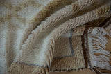 Moroccan rug with ivory fringe, shaggy pile, and coffee brown geometric flat-weave end.