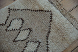 Vintage Moroccan runner with shaggy ivory pile, dark brown primitive pattern, and braided fringe.