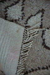 Close-up of Vintage Moroccan rug end, showing woven foundation, braided fringe, and shaggy pile pattern.