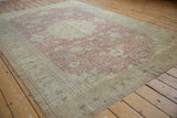 Faded cochineal red and ivory ornate floral field with a detailed patterned border.