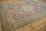 Distressed vintage Kayseri rug corner, with intricate pale olive borders and worn dusty red field.