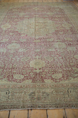 Distressed Kayseri carpet's antique ivory field with dusty red floral vinery and texture.