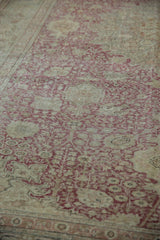 Distressed vintage Kayseri carpet with faded cochineal red floral patterns and exposed foundation.
