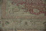 Worn corner of distressed Kayseri carpet, displaying time-softened cochineal red and ivory border.