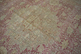 Distressed texture of vintage Kayseri rug with dusty red floral vinery and ivory field.