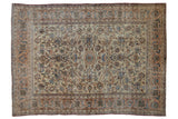 Distressed vintage Isfahan carpet featuring faded floral vinery, ivory field, and apricot border.