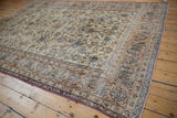Distressed vintage Isfahan rug showing apricot and blue stylized vinery and floral border.