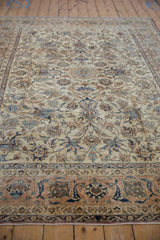 Distressed main border with apricot and navy floral design on a vintage Isfahan carpet.