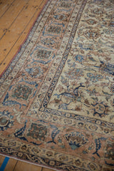 Detailed vintage distressed Isfahan rug corner showing floral vinery and apricot, navy tones.