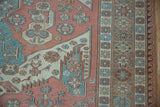 Vintage Soumac rug detail: starburst pomegranate, wave borders, dusty blush and blue.