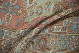 Hand woven Soumac rug detail with distressed pale blush and blue starburst pomegranate border.