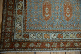 Distressed Malayer runner corner: dusty blue field with rust boteh, playful inner border, starburst main border, fringe.