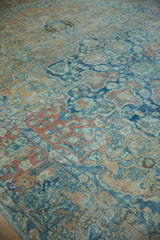 Distressed Northwest Persian rug with sapphire blue, terracotta, and gold floral palmette motifs.
