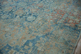Distressed vintage Persian carpet detail with sapphire blue and pale ruby floral palmettes.