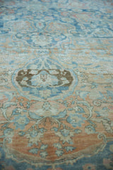 Distressed vintage Persian rug pile detail: faded powder blue, terracotta palmettes, even wear.