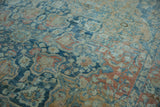 Distressed wool pile shows nuanced sapphire, sand, and terracotta curvilinear patterns.