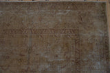 Distressed vintage Sivas carpet pile showing faded gold and aubergine motifs with textural wear.