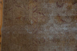Distressed Vintage Sivas carpet pile with faded gold and aubergine lotus motifs, foundation visible.