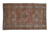 Vintage distressed hand-knotted Persian Karaja rug, geometric medallion, terracotta and blue.