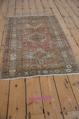 Close-up of distressed Karaja rug corner with fringe, showing worn geometric patterns in dusty rose, blue, and brown.