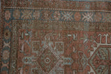 Distressed vintage Karaja rug detail, faded dusty rose, denim blue geometric motifs, worn texture.