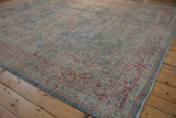 Distressed Mahal rug corner, featuring worn lattice floral design in dusty blue, red, and selvage.