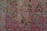 Worn knot heads on a distressed Kayseri carpet show scalloped floral details in fuchsia and faded teal.