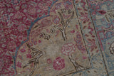 Tree of life and bird motifs on the distressed low pile of a vintage Kayseri rug.