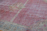Distressed texture and color abrash on the fuchsia field and ivory corner of a vintage Kayseri carpet.