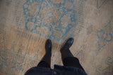 The distressed texture of the vintage Veece carpet with visible knot heads and foundation.