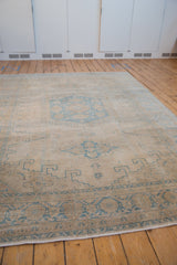 Low angle of a distressed Persian Veece rug showing its even wear and soft palette.