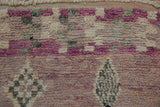 Distressed shaggy pile showcases abstract dusty rose, ivory, and grey patterns on a Moroccan rug.
